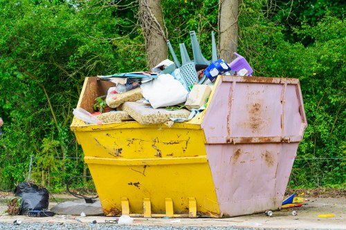 Construction workers loading waste into a large builders skip